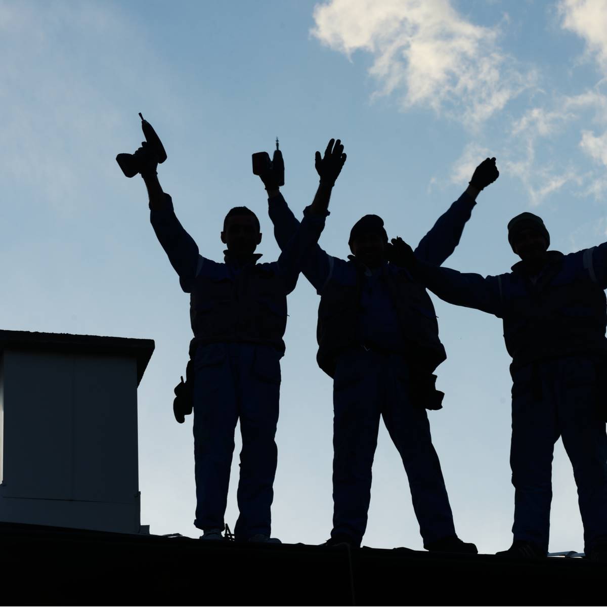 Cypress roofers standing on compelted roof replacement in celebration of a job well done.