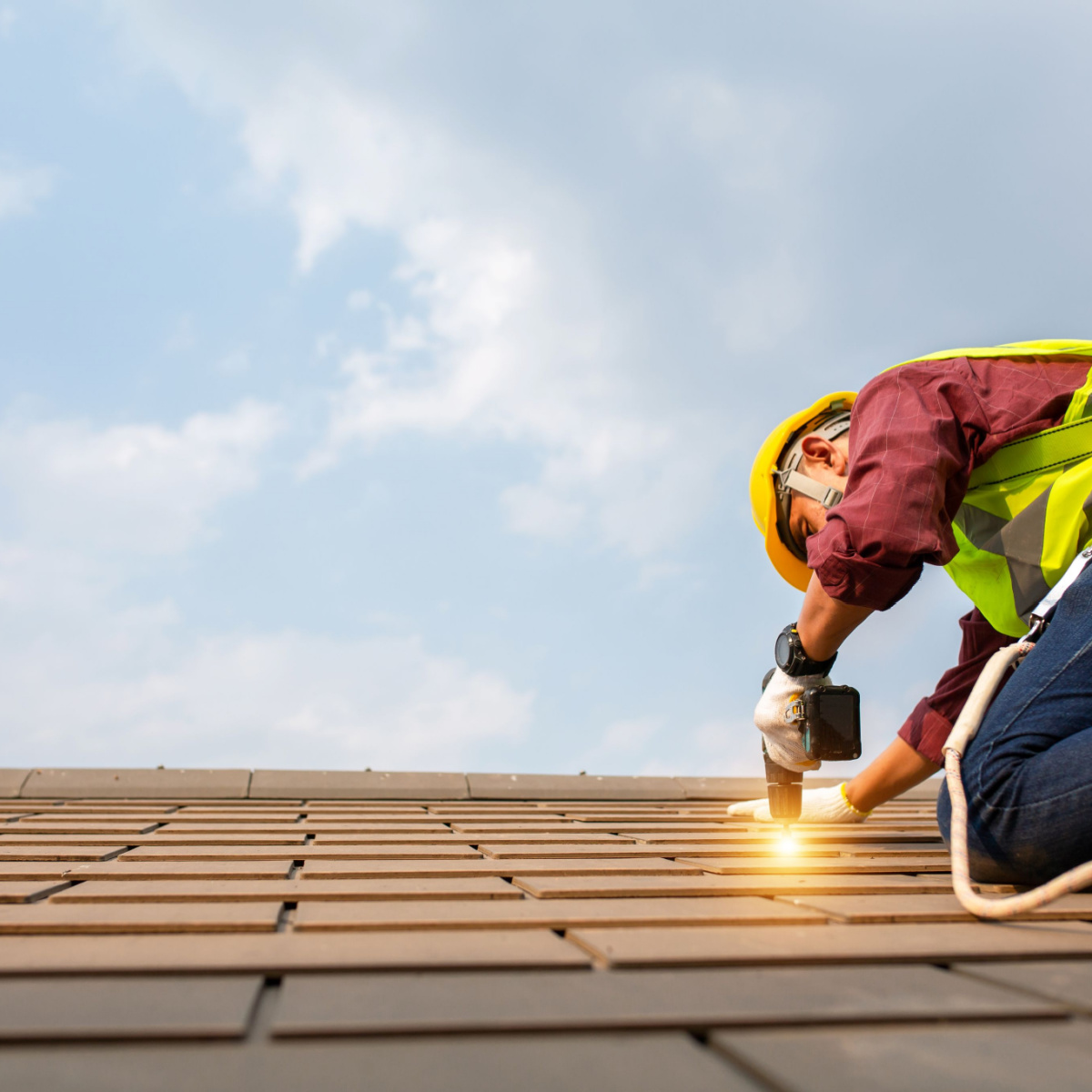 A roofer replacing shingles