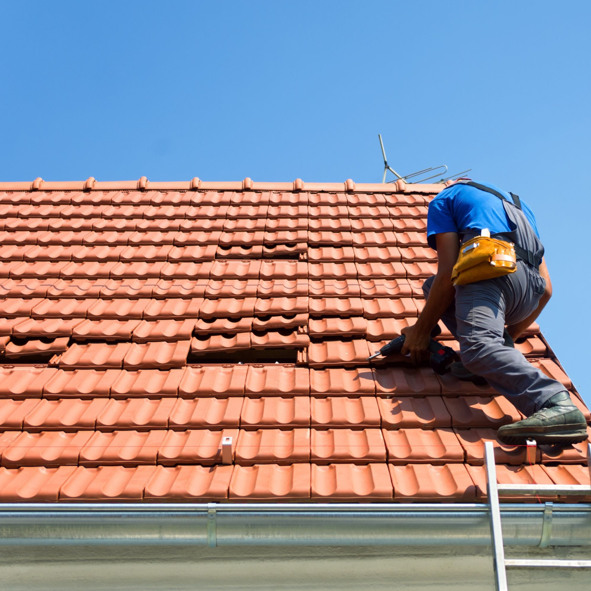 A man replacing roof shingles