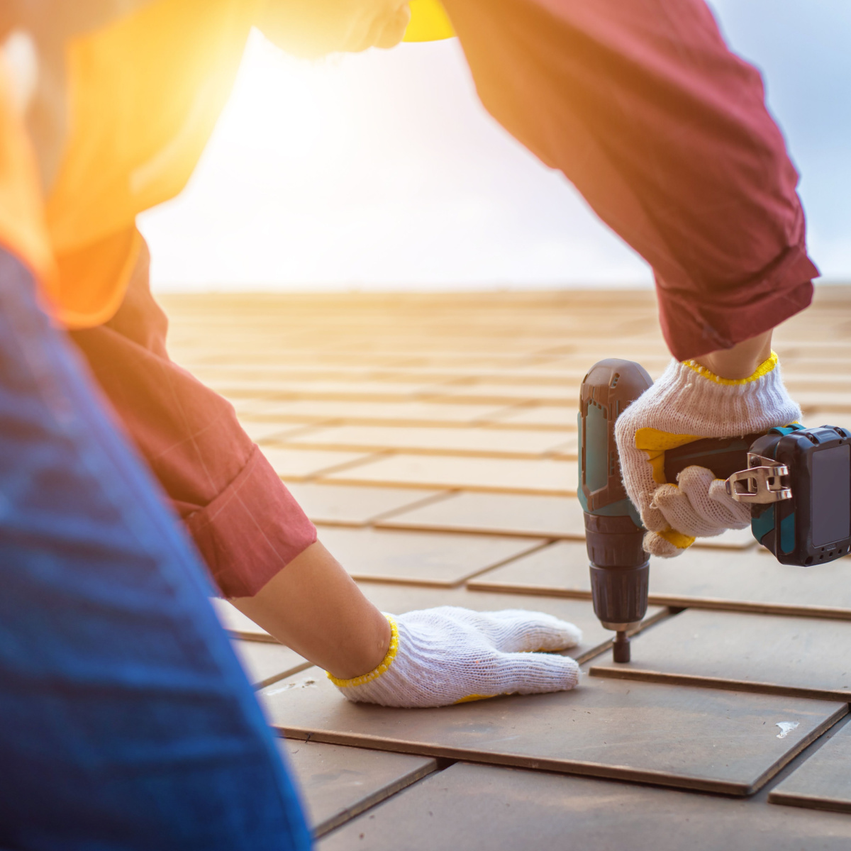 A roofer nailing down shingles